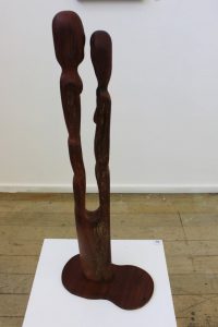 A curved wooden sculpture of two human forms