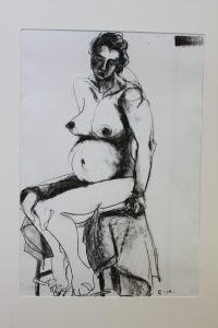 A charcoal sketch of a nude woman seated on a chair