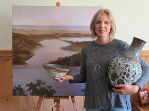 Judy Rauert holding two ceramic pieces at the 'Tower Hill Inspired' exhibition at the Outlaw Gallery