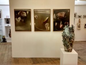 Three abstract paintings and a large ceramic urn