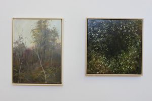 Two paintings, one of the Australian bush and one of flowers on a plant